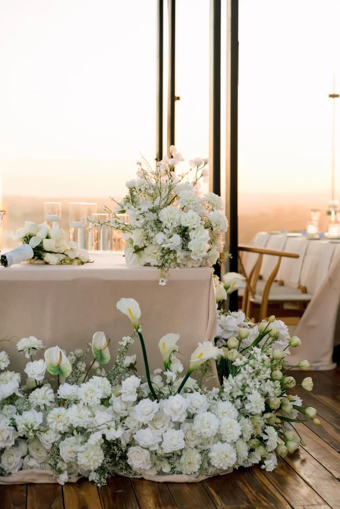 Golden hour at the reception, table set with white florals overlooking the ocean